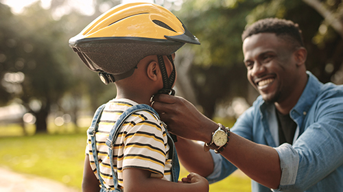 Father fitting cycling helmet